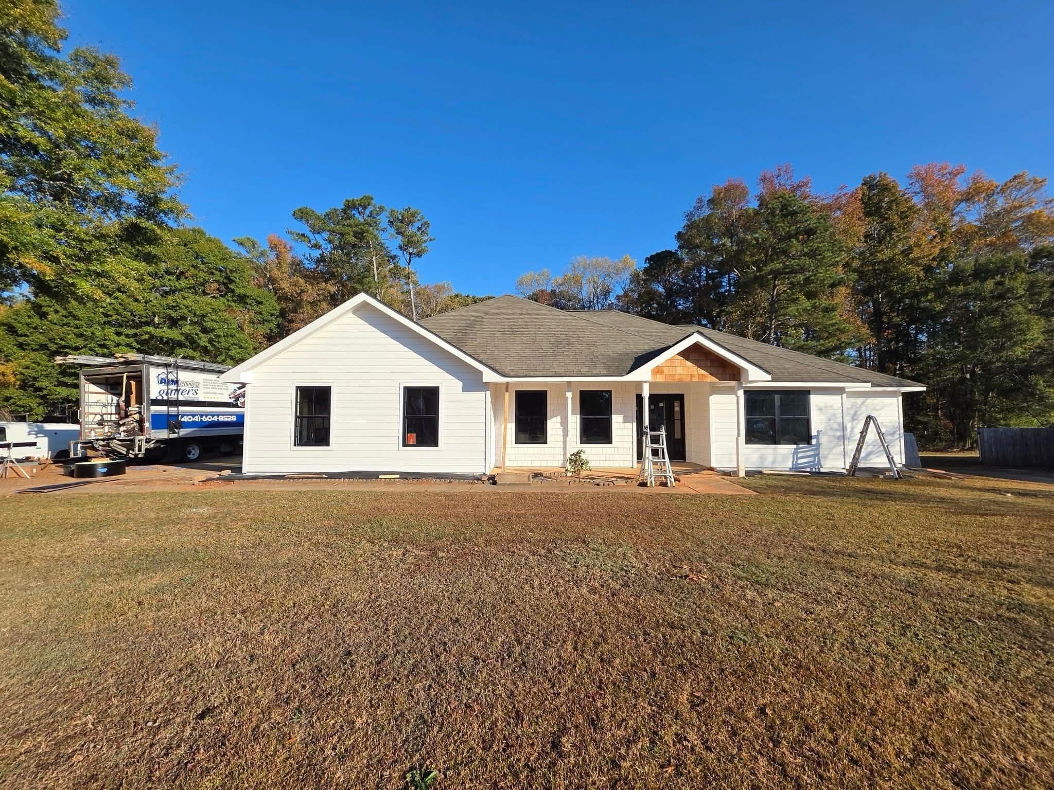 New construction home with black seamless gutters — side view showing clean roofline